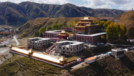 Gorgeous-Bamei-temple-overlooks-Tagong-grasslands-of-Tibetan-Sichuan-Western-China,-aerial-establish