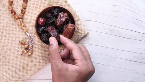 hand picking dates from a bowl