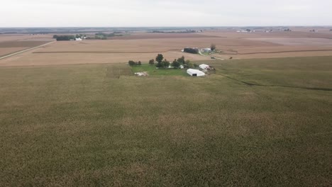 Aerial-drone-view-in-rural-Iowa-with-a-view-of-corn-fields-and-farms-with-barns-and-silos