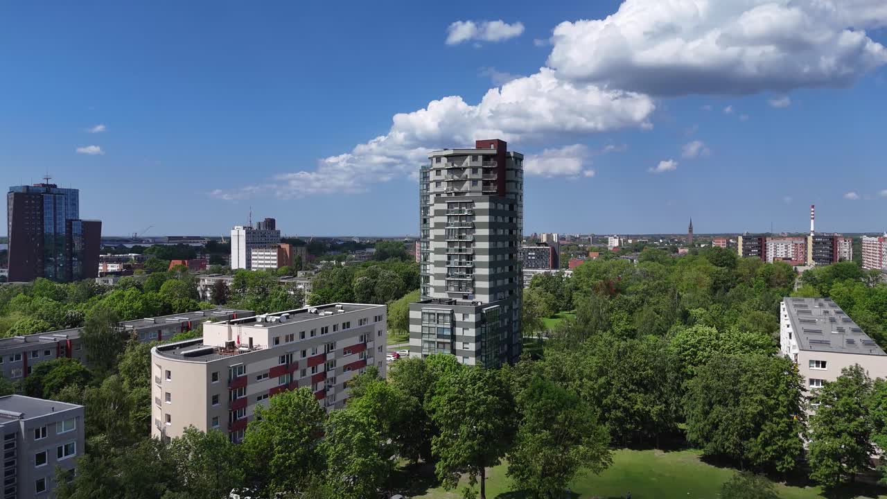 la ciudad de klaipeda con edificios altos y parques verdes bajo un cielo azul, vista aérea