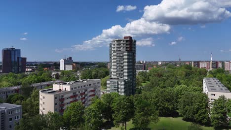 Klaipeda-city-with-tall-buildings-and-green-parks-under-a-blue-sky,-aerial-view