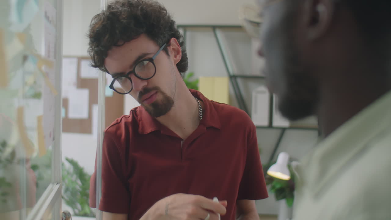Man Discussing Business Tasks on Sticky Notes with Colleague