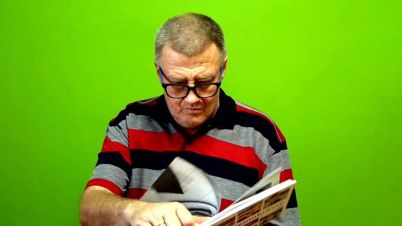 un adulto de etnia caucásica en ropa casual lee un libro, levanta la cabeza,