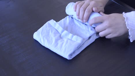 footage of how you can tightly fold and roll a pair of jeans