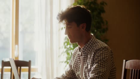 young man working on laptop at home