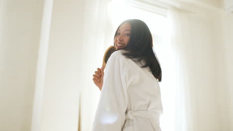 woman singing while brushing her hair