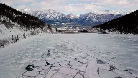the white frozen lake in the beautiful spray lakes reservoir in canada during winter - aerial