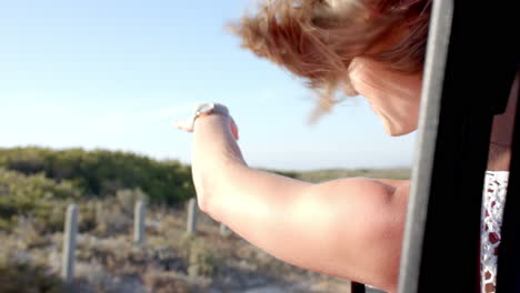 Young-Caucasian-woman-enjoys-a-sunny-outdoor-adventure-on-a-road-trip-with-copy-space