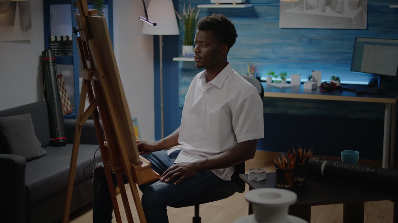African american artist sitting in drawing studio