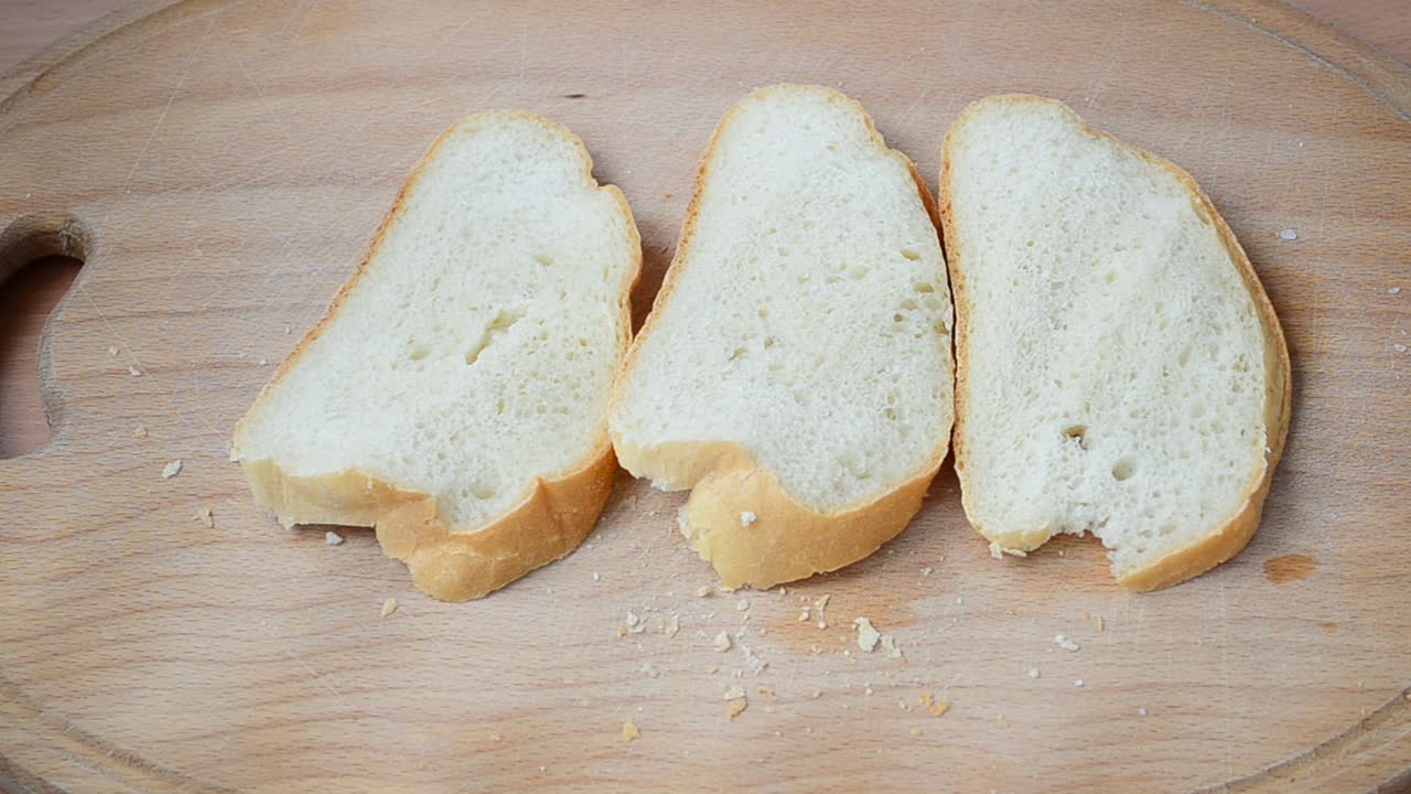 Cutting of bread on a board. Cutting of bread