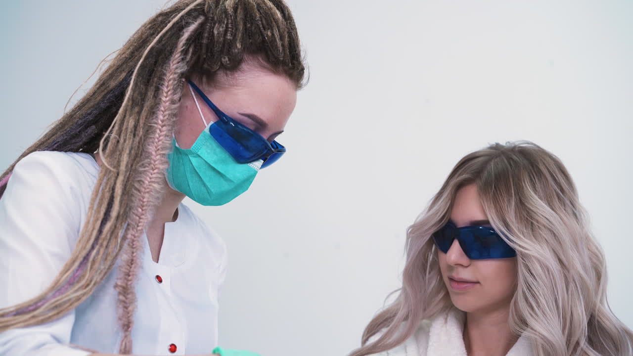 una mujer bonita habla con un cosmetólogo en una depilación láser