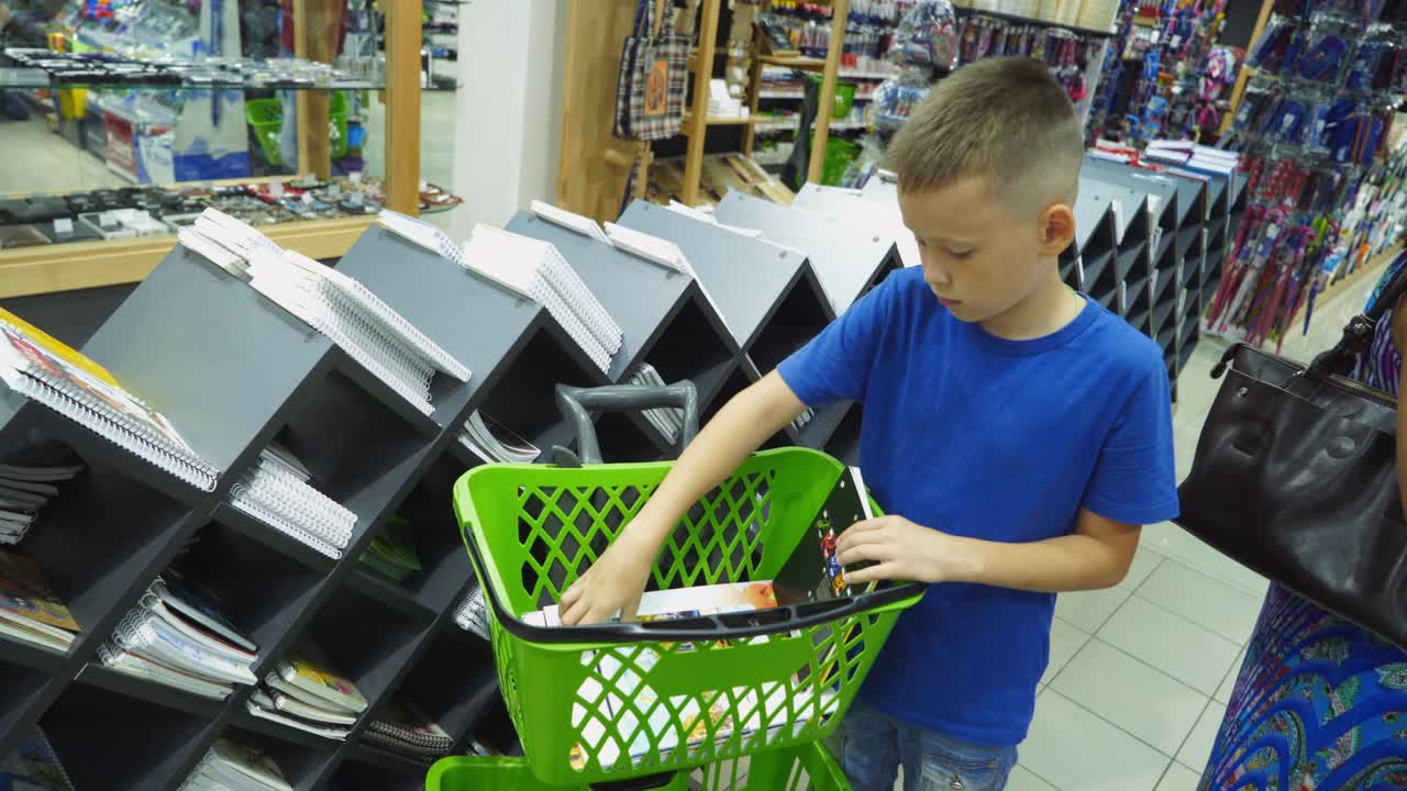 VINNITSA, UKRAINE - AUGUST 20, 2018: Shopping for school. Boy buying different products in stationery shop.