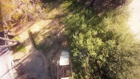 Overhead-aerial-of-an-abandoned-carnival-with-a-ferris-wheel-on-a-bright-day