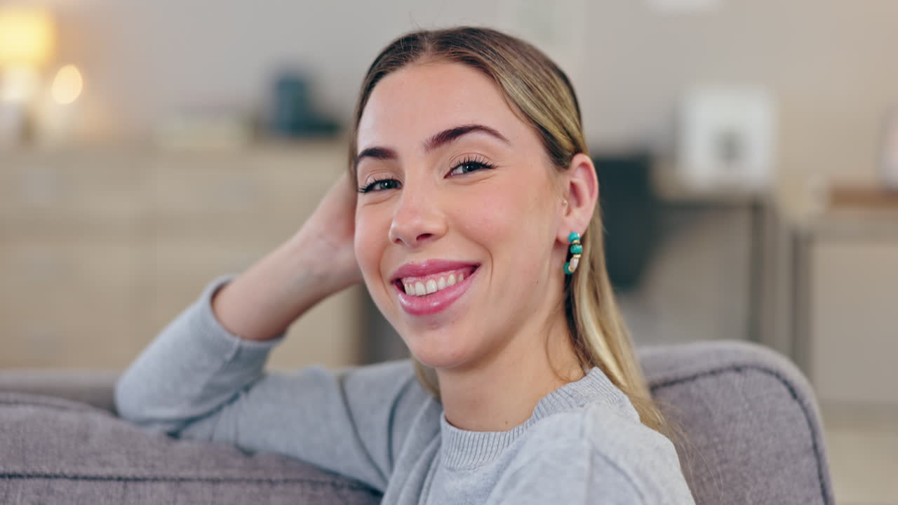 feliz, sonrisa y rostro de una mujer en un sofá a