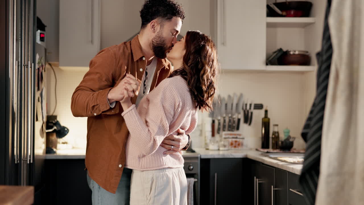 um casal a dançar na cozinha.