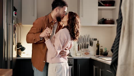 una pareja bailando en la cocina.