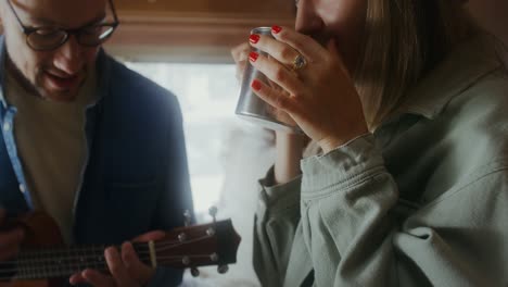 couple enjoying music and drinks in their campervan