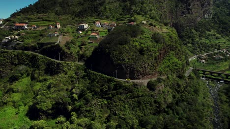 4k aerial of yellow car driving uphill on steep road in mountains