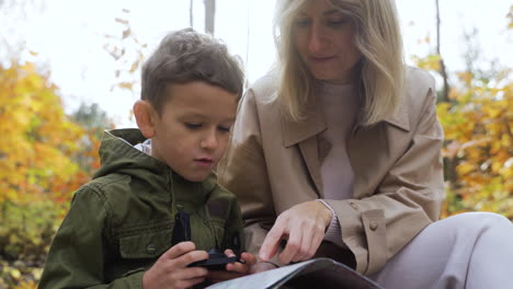 mutter und sohn sitzen im wald