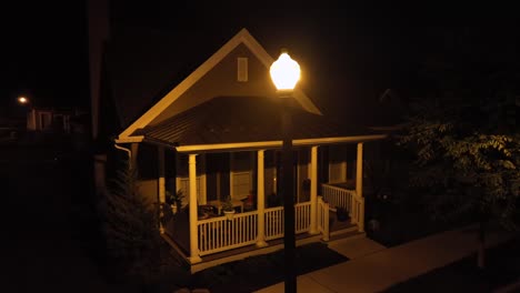 aerial orbit shot of lighting lantern in american housing area. porch veranda of american home at night. close up. dark city suburb of pennsylvania state.