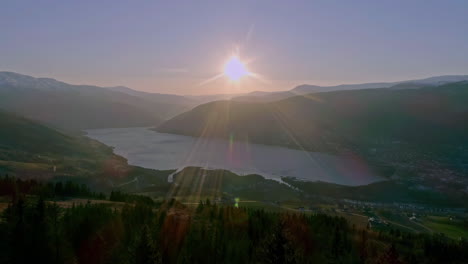 Disparo-En-ángulo-Alto-Sobre-La-Ciudad-A-Lo-Largo-De-La-Ladera-De-Una-Montaña-Con-Un-Río-Que-Fluye-A-Través-De-La-Cordillera-En-Noruega-En-Un-Día-Soleado-Y-Brillante