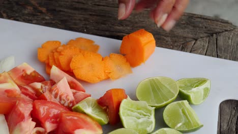 cutting carrots with knife on chopping board, close up