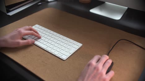 man using his mouse and keyboard in his office