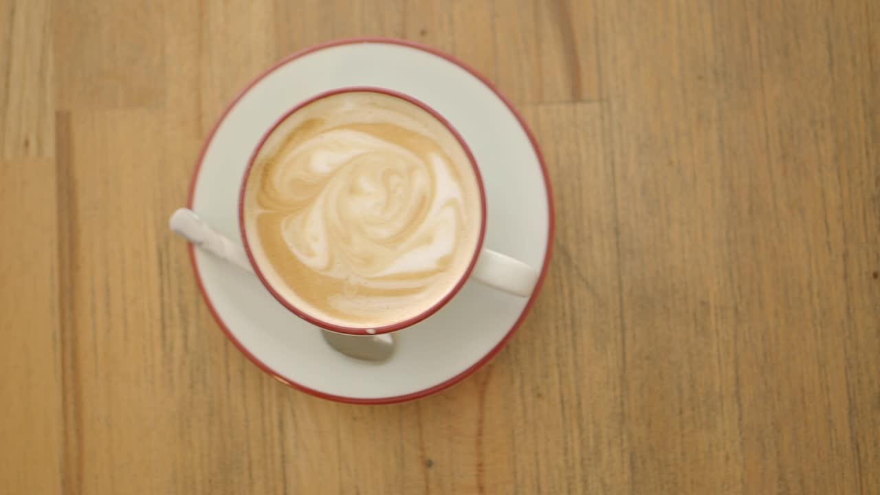 Tazza da caffè con latte art su un tavolo di legno, vista dall'alto