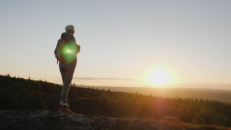una mujer activa llega a la cima de la montaña con una vista impresionante abajo viajando en nor