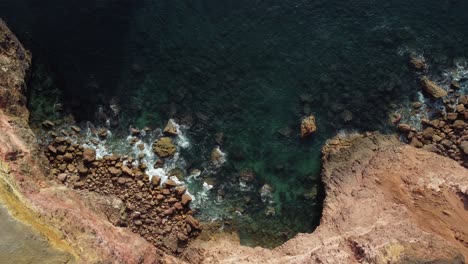 topdown view of rocky coastline with fog in the portugal southeast