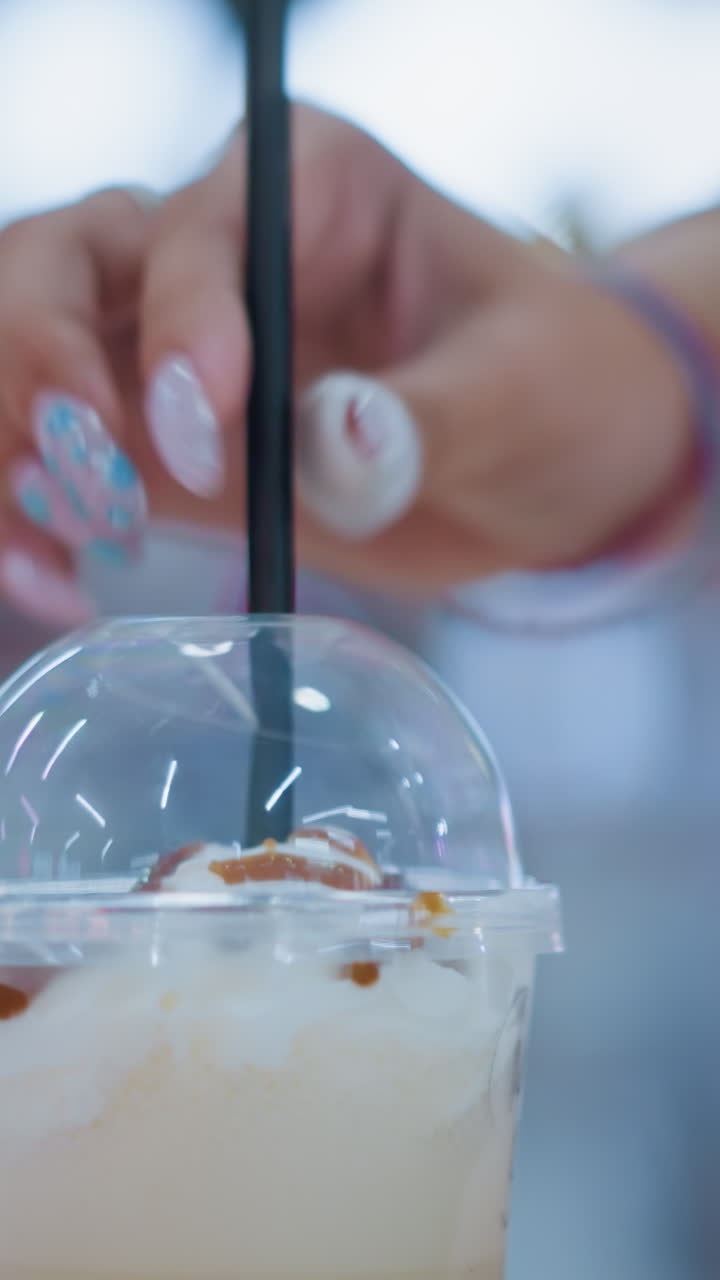 테이블 위에 두 개의 크림 음료가 검은 을 입하는 사람과 함께, 부드러운 보케 조명과 레스토랑에서 사람들의 움직임을 보여주는 흐릿한 배경으로 캐주얼 식사 분위기를 만니다.