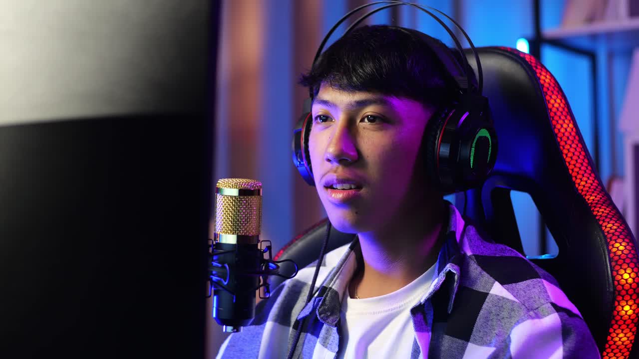 아시안 소년 스트리머가 소리 지르며 골을 치며 pc에서 네트워크를 통해 우승 게임을 축하합니다. 라이브 스트리밍 비디오 게임, rgb led 스트립 라이트에 의해 조명 된 책상