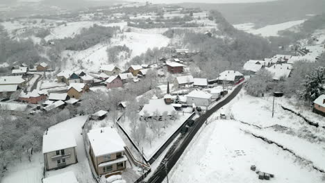 Circle-shot-around-a-church-over-a-village-in-wither-with-snow