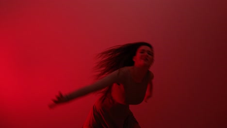 young artistic woman expressing herself in blood red room dancing