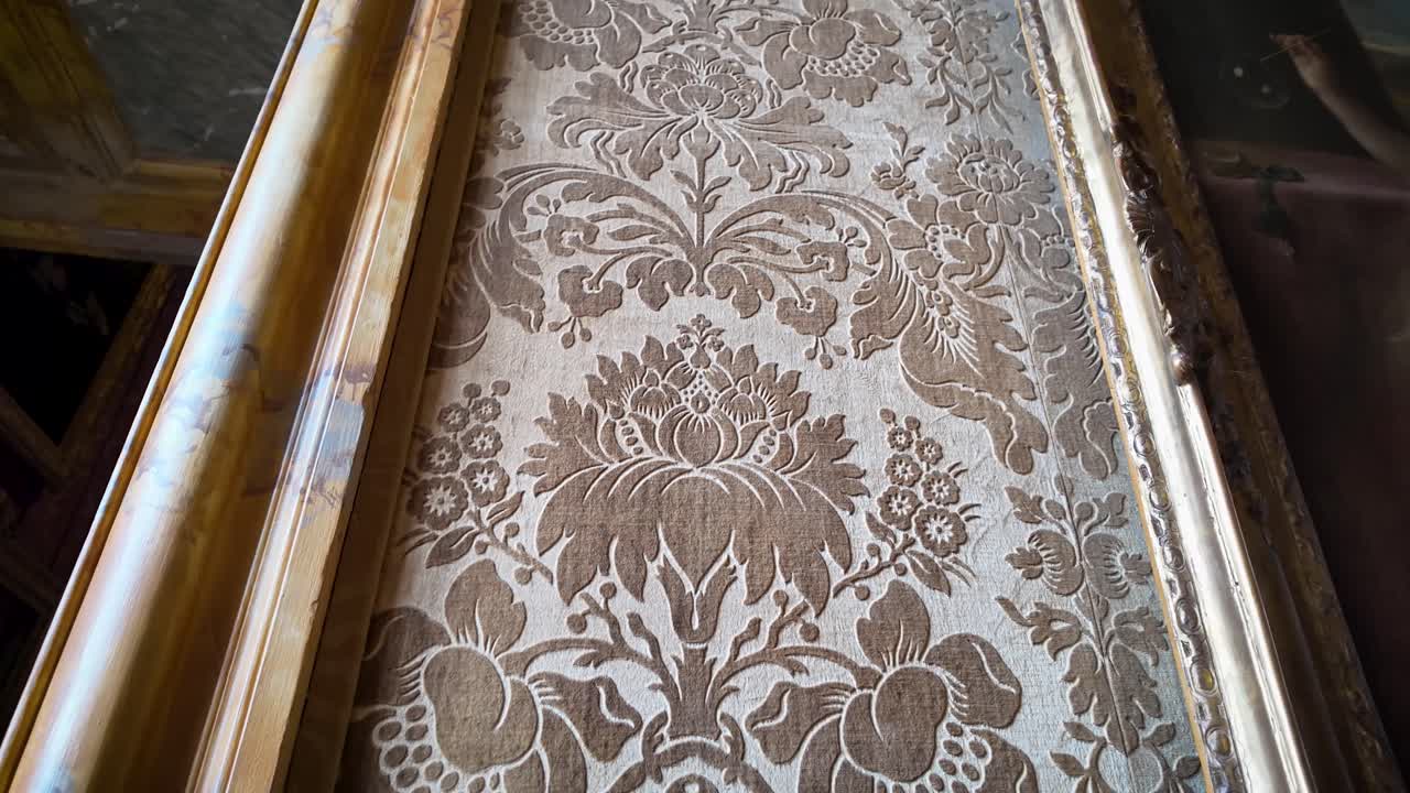 Detailed video of light-toned, velvet-like wallpaper with organic motifs decorating the wall beside a doorway inside the Palace of Versailles, highlighting texture, craftsmanship and elegant design