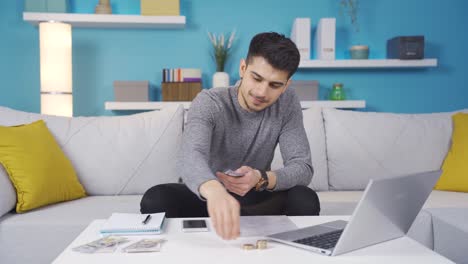 joven feliz que usa sus facturas y cuentas bancarias regularmente y con moderación.