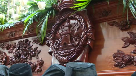 ornate wooden carvings and floral decorations of a religious procession