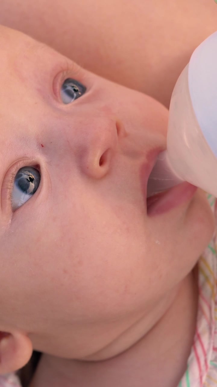 Mamma che dà da bere acqua al bambino dal biberon