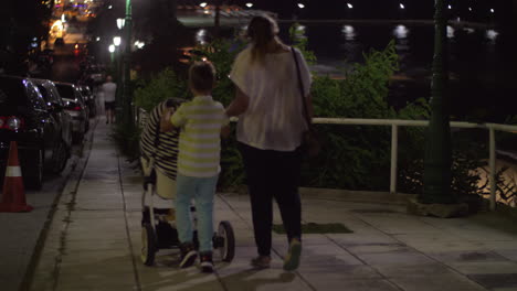 mother having evening walk with elder son and baby