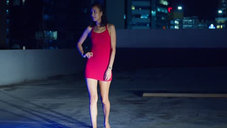 on a rooftop, a hispanic girl stands with the bright lights of port of spain, trinidad in the caribbean background