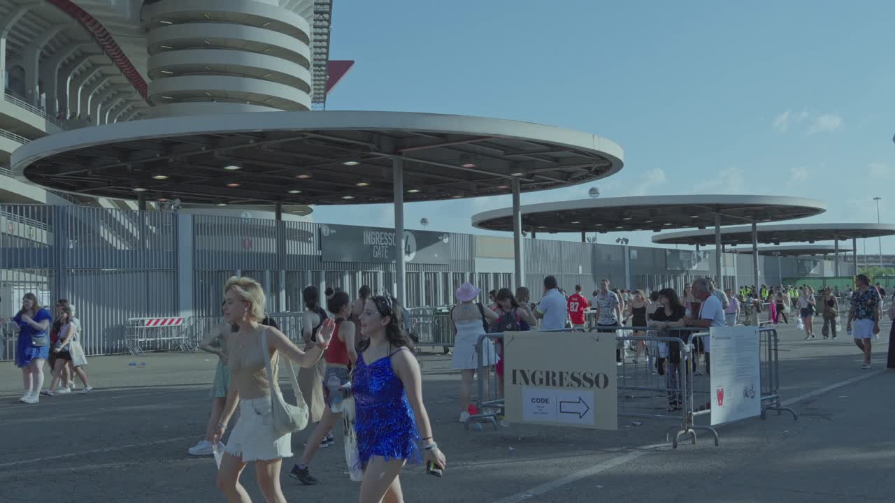 People gathering at an event stadium entrance gate