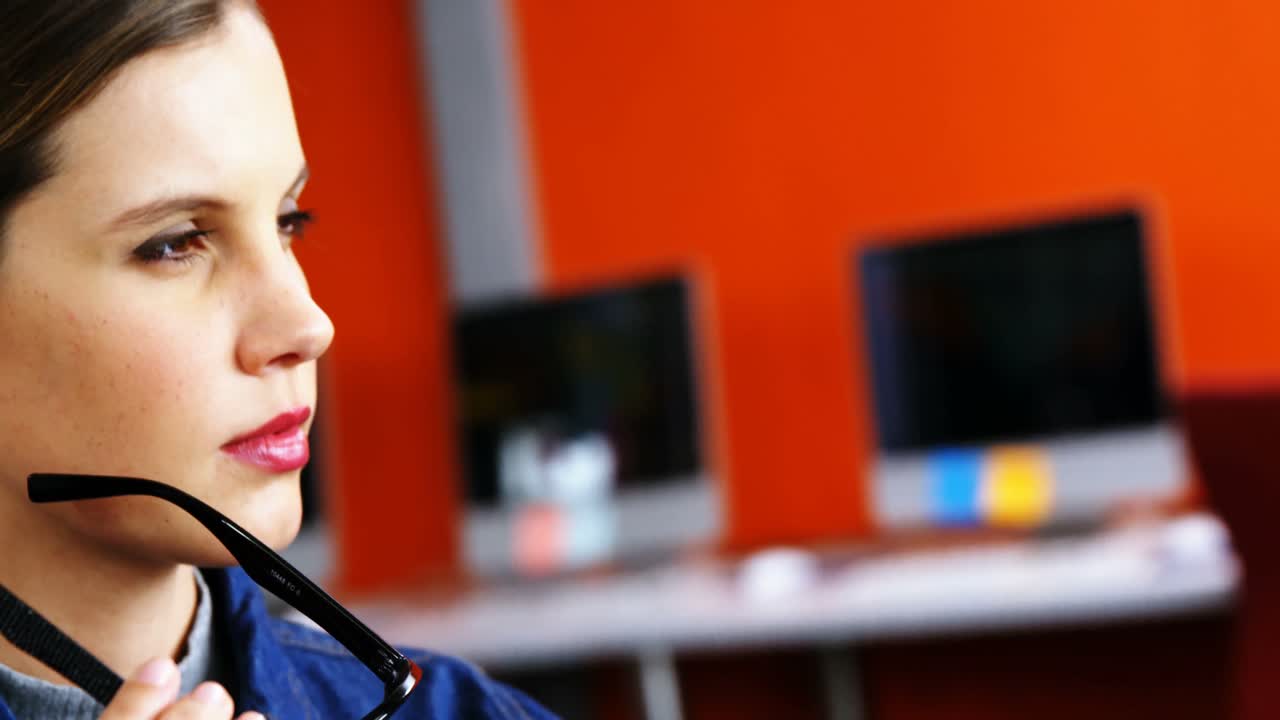 mujer ejecutiva pensativa de pie con gafas