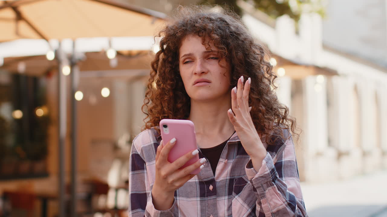 Surprised young woman use smartphone loses bad news fortune loss fail outdoors in city street