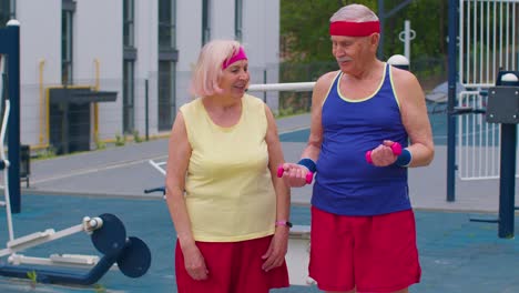 anciano activo equipo deportivo abuela abuelo levantando pesas pesas, sonriendo a la cámara
