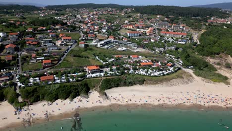 Imágenes-De-Inclinación-Aérea-De-Resorts-Frente-Al-Mar-En-Un-Pueblo-Sereno-Y-Bosques-Verdes