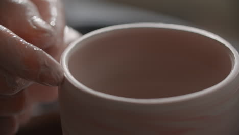 hand-building a pink ceramic cup