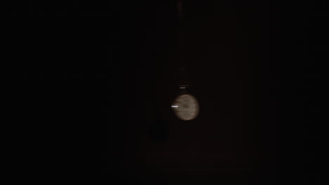 pocket watch swings fast on a dark background