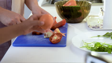 Close-up-view-of-mother-and-daughter-hands-cutting-vegetables.