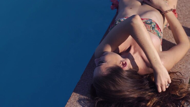 Young Woman Relaxing by the Swimming Pool