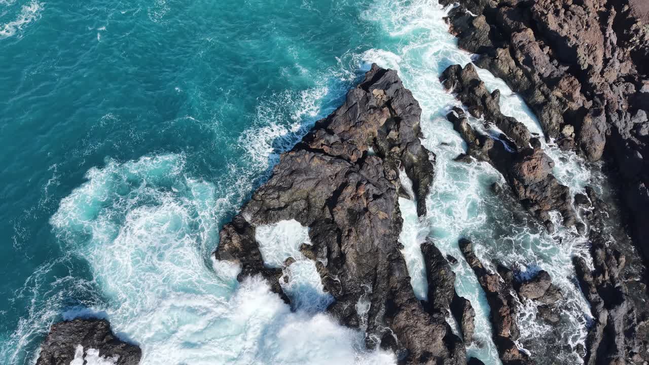 Onde nere che si infrangono su rocce vulcaniche a Tenerife, Spagna